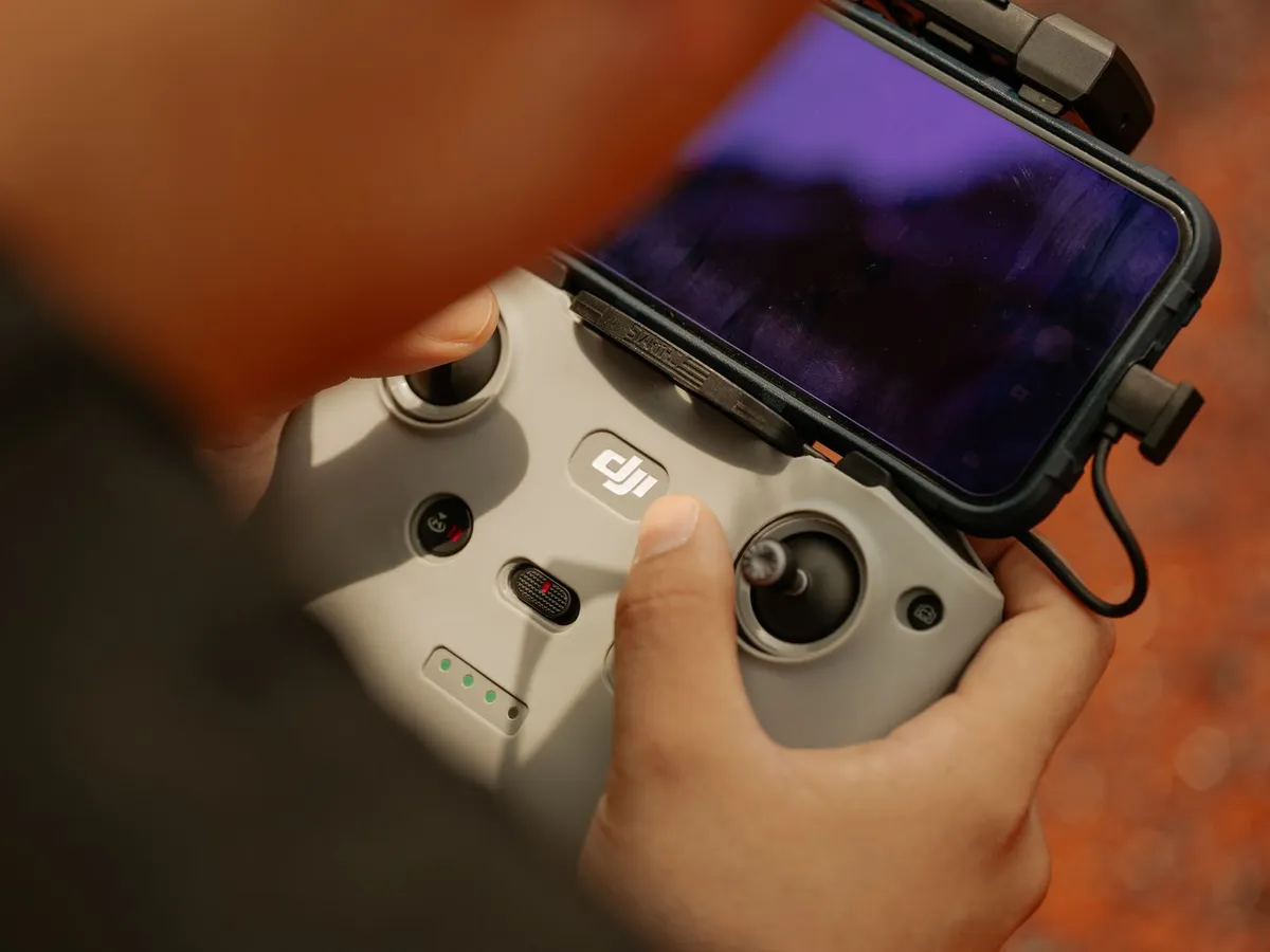 Drone remote controller in hand during a mission — piloting and live monitoring of the images